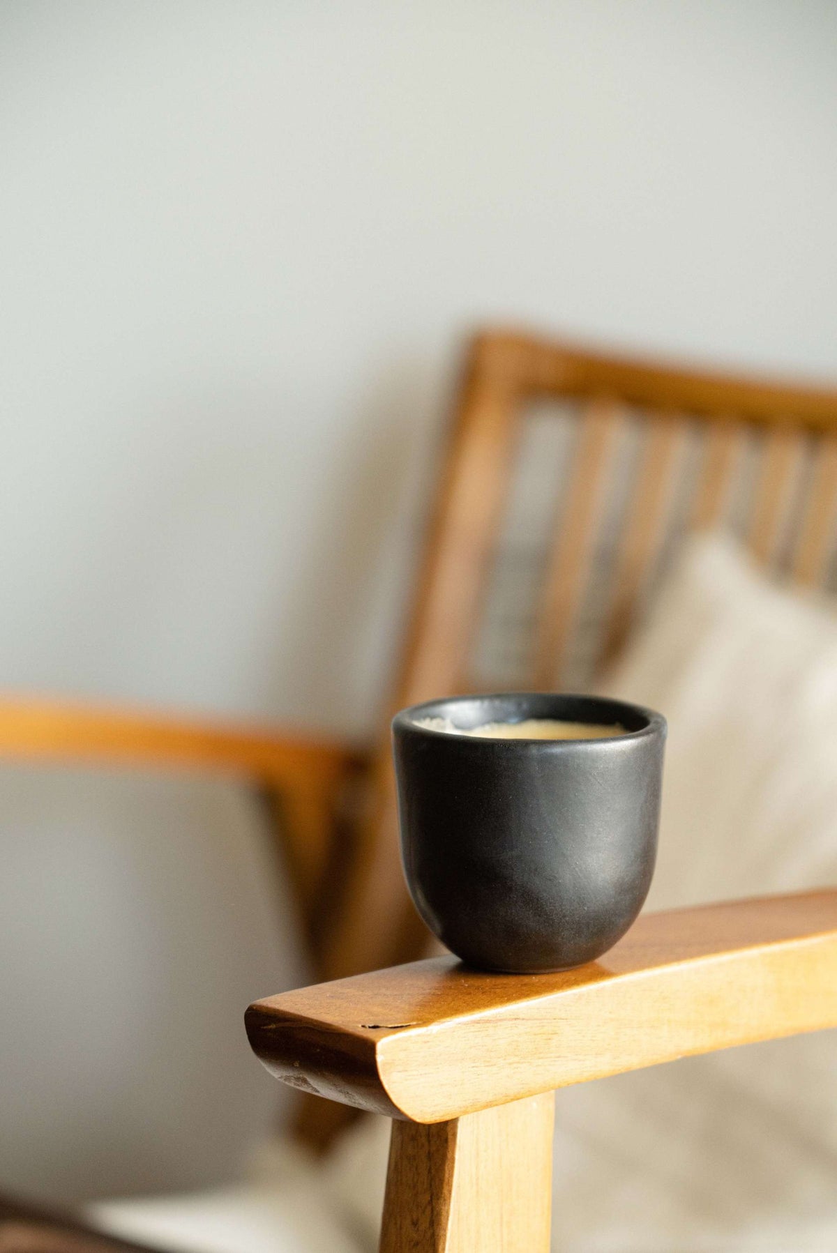 Handmade black stoneware espresso cup with organic edges and reactive glaze