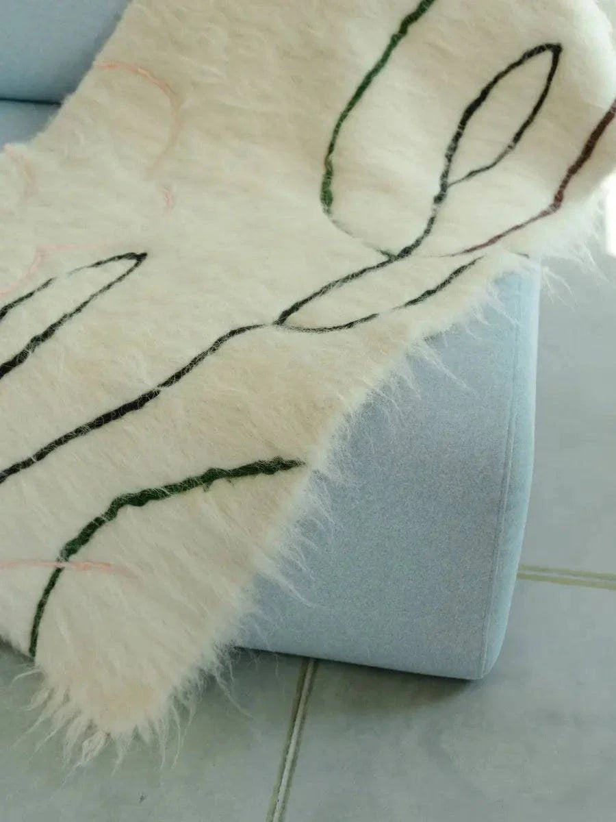 Handwoven wool runner rug with creamy floral design on cotton base