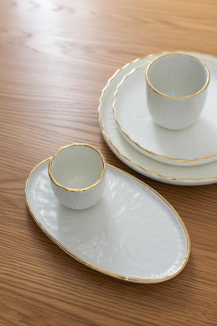 Handmade Porcelain oval serving platter in off-white with a textured relief surface and fine gold rim
