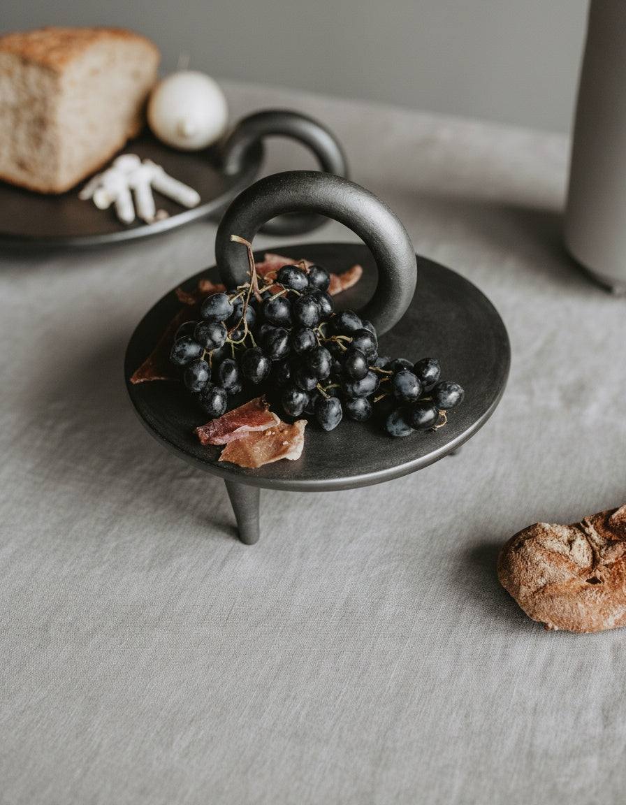 Small black smoked ceramic pedestal platter handcrafted in Ukraine by Danuta Kril