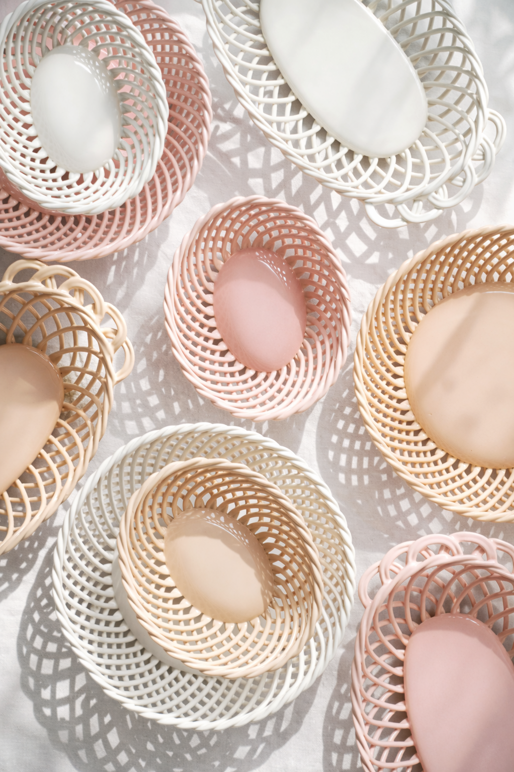 Ceramic Round Hand-Woven Basket in glossy white, beige, and pink porcelain, with an open crisscross weave and oval centers.