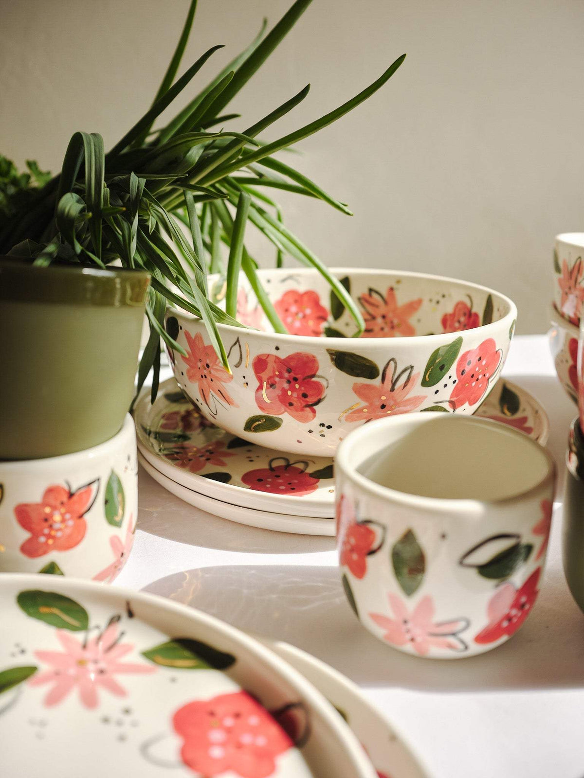 Hand-Painted Floral Coffee Cup in cream porcelain, decorated with red and pink flowers, green leaves, and a curved handle.