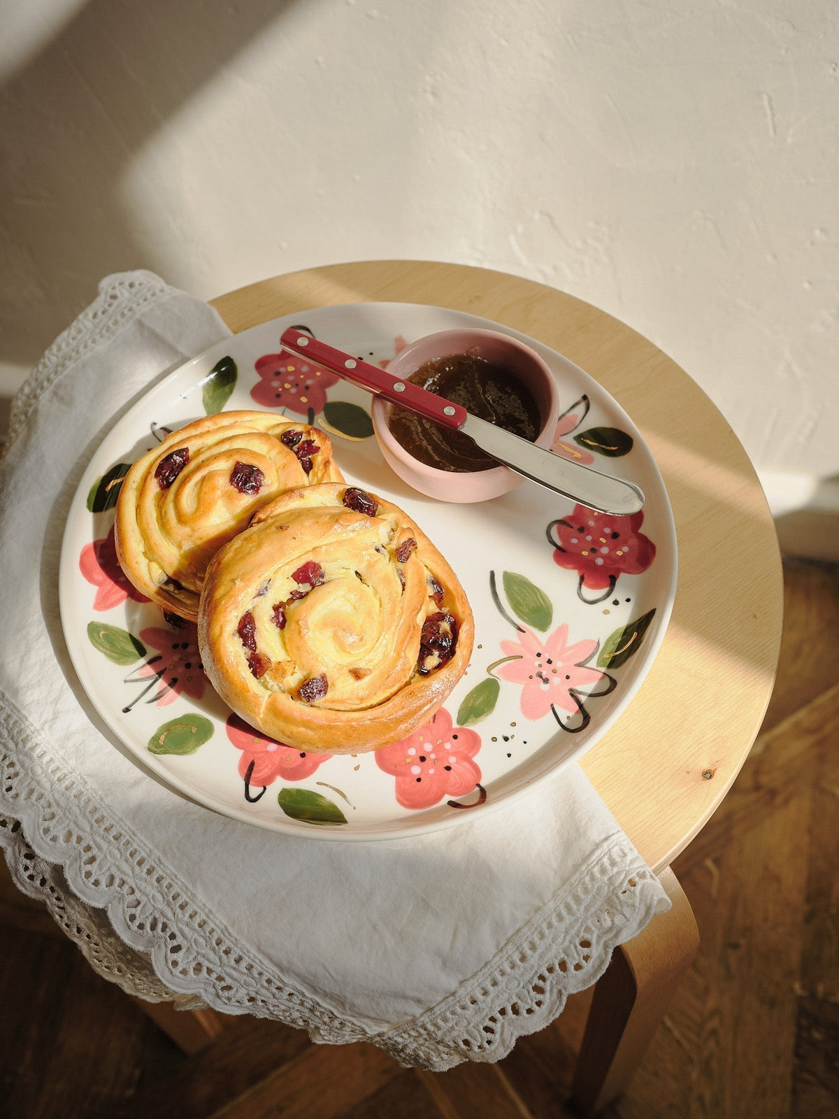 Hand-Painted Floral Dinner Plates are off-white porcelain with bold red, pink, and green floral motifs and a yellow rim.