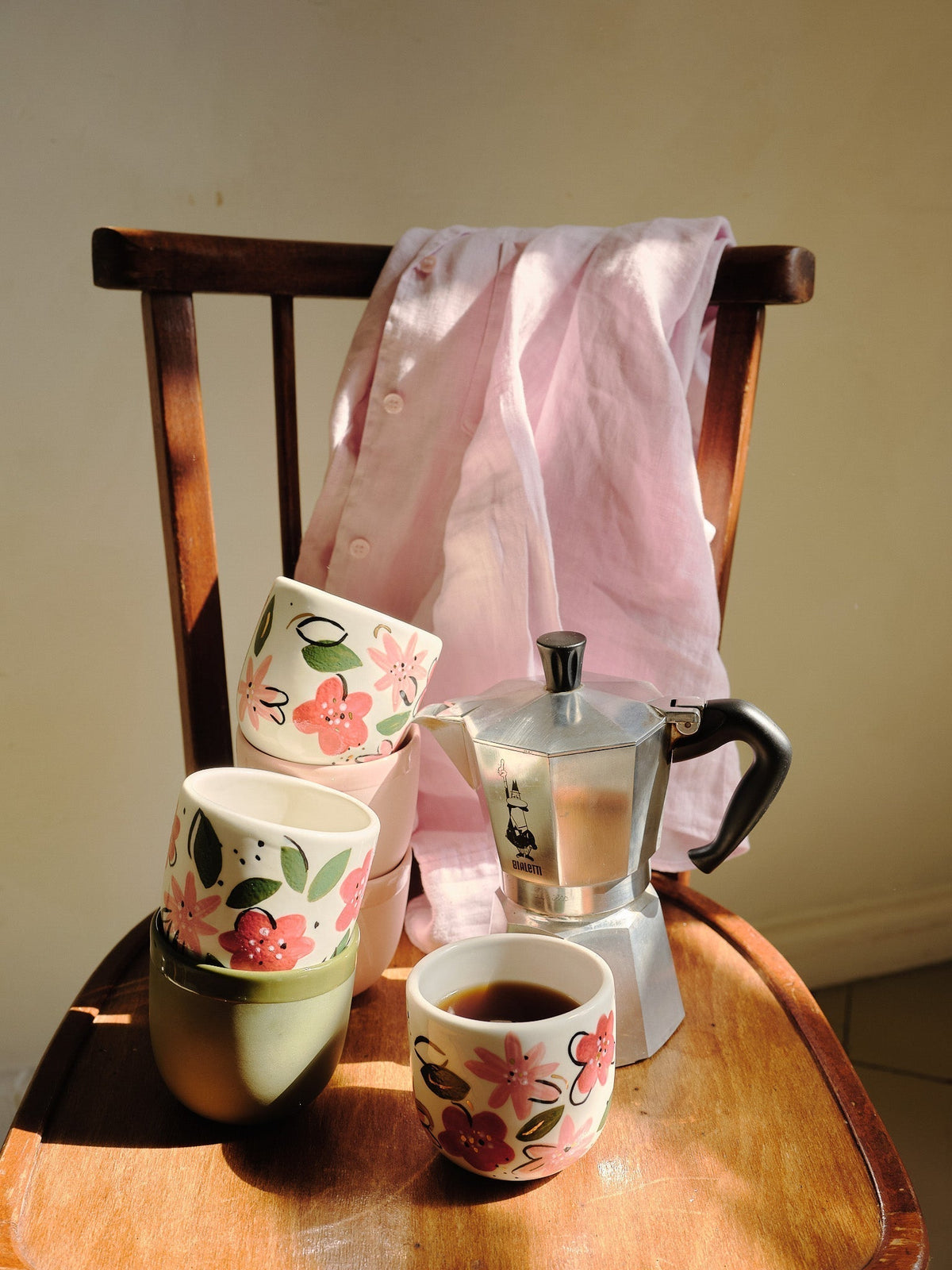 Hand-Painted Floral Coffee Cup, cream porcelain mug with pink and red flowers, green leaves, and a pale green rim