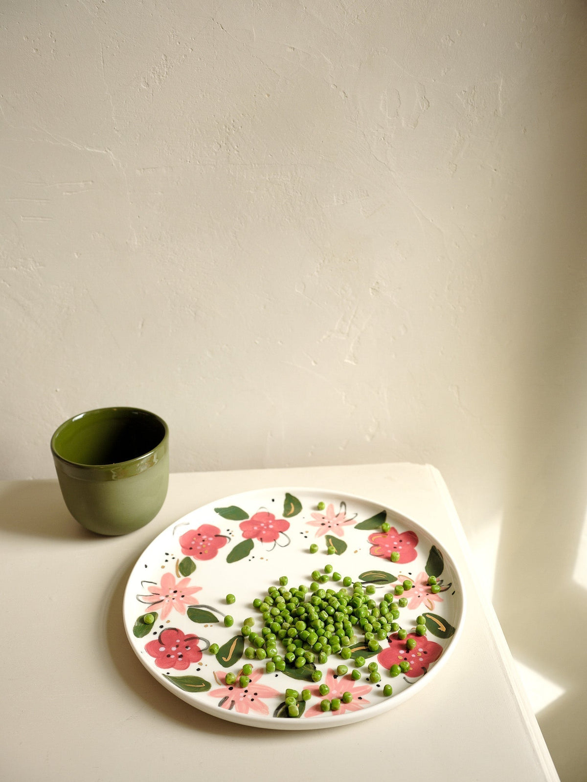 Hand-Painted Floral Dinner Plates are off-white porcelain with hand-painted pink and red flowers, green leaves, and gold accents.